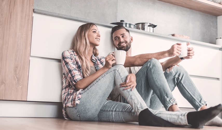 Młoda para odpoczywa w czystej kuchni – efekt zlecenia sprzątania profesjonalnej firmie sprzątającej MultiTask