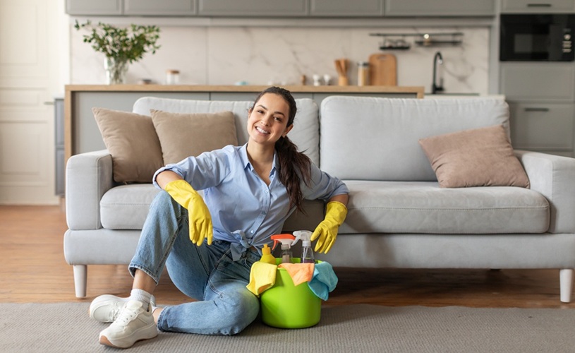 Zadowolona sprzątaczka MultiTask24 siedzi na podłodze po zakończonym sprzątaniu – satysfakcja z dobrze wykonanej pracy